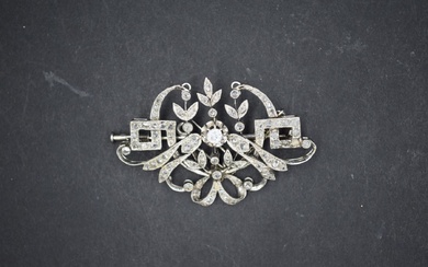 Broche en or gris 18k (750) à décor de volutes ornées de diamants. Circa 1925....
