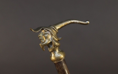 Cane with bronze knob featuring a character's head with pointed cap. Traces of silver plating. Height 86,5 cm