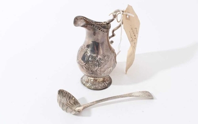 George III Irish silver cream jug with repousse cattle in landscape panels, scroll handle and circular pedestal foot (Dublin 1792), together with a George IV Irish silver cream ladle (Dublin 1826),...