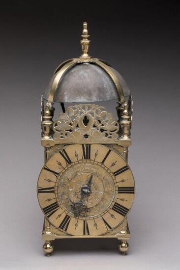 LANTERN CLOCK LANTERN in brass, topped by a spinning top supported by four others joined by a spacer above the bell. Each one rests on a Doric column. Three pediments decorated with dolphins with intersecting bodies surrounded by foliage and flowers...