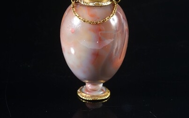 MINIATURE PERFUM BOTTLE,MILAN, late 16th C. In the form of a vase, carved from a block of blonde agate, topped with a gold stopper decorated with a finely carved rose. Gold mounting partially enamelled with white, held by two links to a gold...