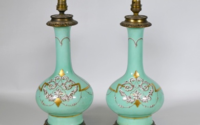 Paire d'anciennes lampes à pétrole, les prises en porcelaine peinte et dorée à décor de...