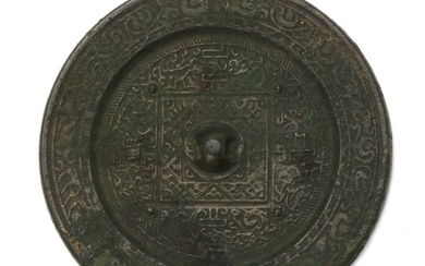 A Chinese patinated bronze mirror cast with archaic motifs. Ming, 17th century. Diam. 14 cm.