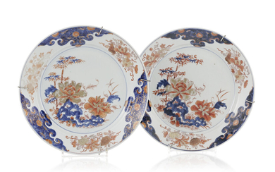 2 plats en porcelaine Imari, Chine, XVIIIe s., décor de fleurs, fruits et rochers, diam. 32 cm (éclats)