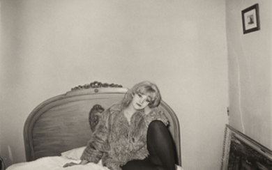 DIANE ARBUS (1923-1971), Girl in a coat lying on her bed, NYC, 1968
