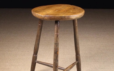 A 19th Century Cricket Table. The round twin plank top on three turned legs united by a turned T-fro