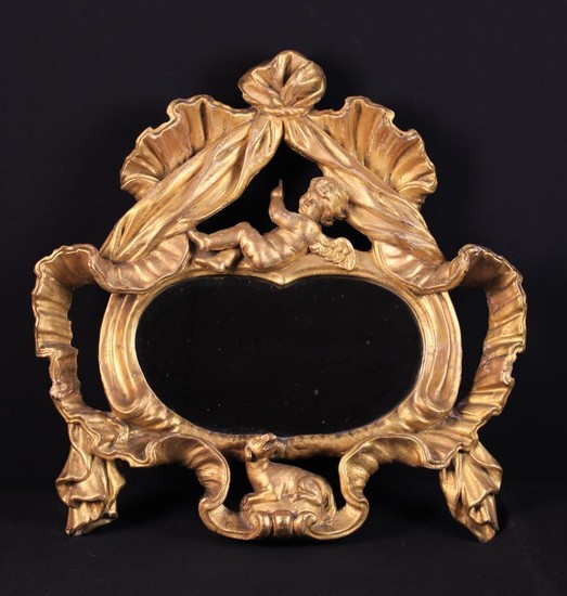A 19th Century Oval Wall Mirror set in an open carved giltwood frame. The top surmounted by a cavort
