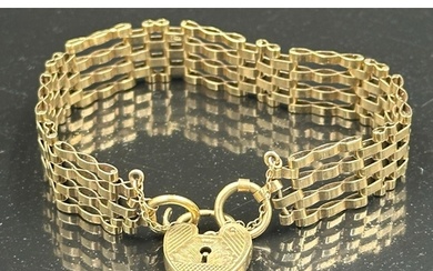 A 9ct yellow gold gate bracelet with heart shaped fastner, a...