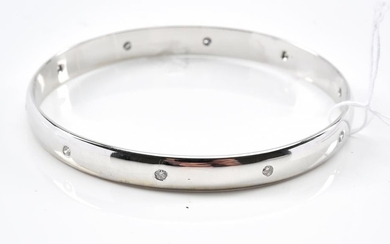 A BANGLE WITH TEN HAMMER SET DIAMONDS IN 9CT WHITE GOLD