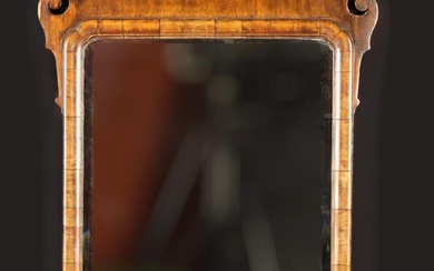 A Georgian Wall Mirror. The bevel-edged rectangular glass in a moulded frame with re-entrant upper c