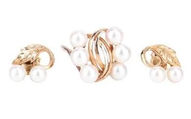 A Mikimoto pearl ring and earrings; the ring of stylised foliate design and set obliquely with six c