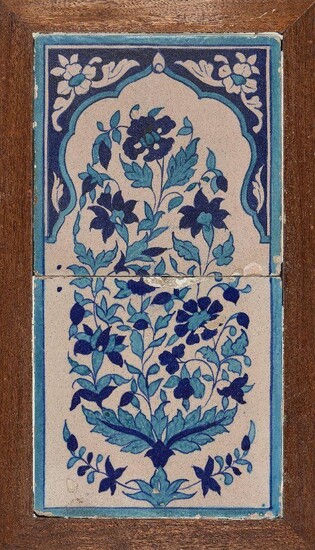 A Multan pottery tile panel with floral decoration, North India, early 19th century, formed of two tiles decorated in turquoise and cobalt and depicting a floral spray within a cusped arch, set in a wood frame, 52 x 30cm.