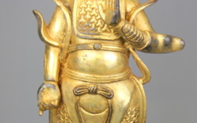 A Tibetan gilt bronze figure of a standing deity, H. 29cm.