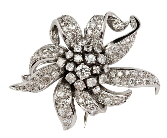 A diamond flowerhead spray cluster clip brooch, the stylised flower with central brilliant-cut diamond domed cluster with pave diamond set petals, c.1960, maximum width 5.0cm, French import marks