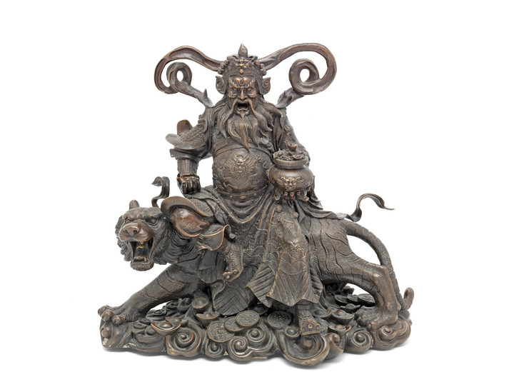 A late 19th / early 20th century Asian bronze model of a deity seated on a tiger, possibly showing the god of wealth Tsai Shen Yeh