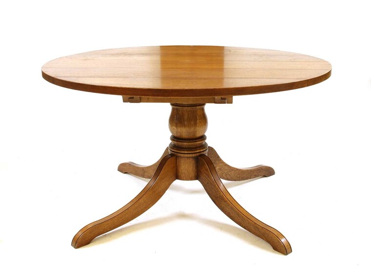 A modern solid oak extending pedestal dining table
