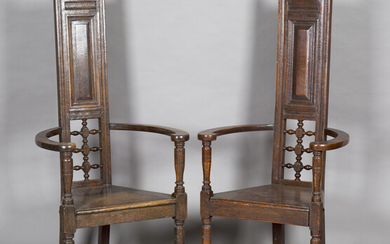 A near pair of early 20th century Arts and Crafts stained oak 'Shakespeare' armchairs, in