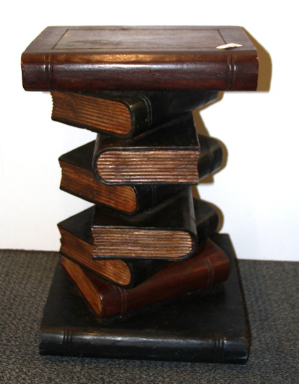 A painted and carved wooden pile of books wine table, H. 50cm.