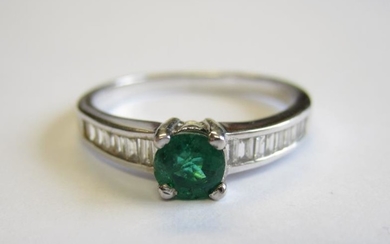 An Emerald and Diamond Ring claw-set round emerald between...