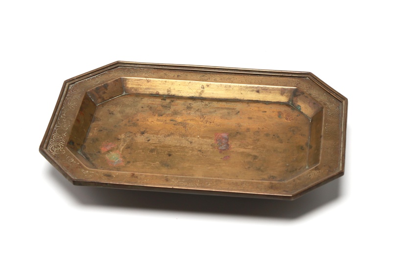 An eight-sided brass tea tray decorated with scrolling lotus at rim