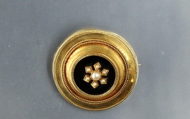Broche ronde en or 18k (750) ornée de perles sur plaque d'onyx. Poinçon tête d'aigle....