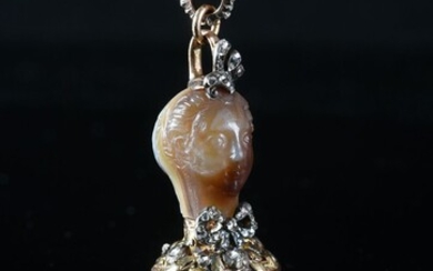 CACHET PENDANT SEAL, FRANCE, 19th CENTURY. Decorated with a woman's head in the antique style, carved in a block of agate, topped with an aigrette set with diamond roses holding a yellow gold clasp set with diamond roses and adorned around the neck...