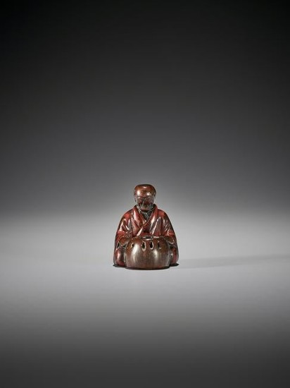 EARLY LACQUERED WOOD NETSUKE OF A MAN WITH HIBACHI
