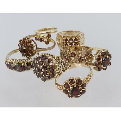 Eight 9ct yellow gold rings set with garnet to include a lar...