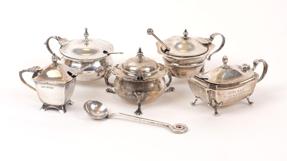 Five Edwardian and later silver mustards, and several condiment spoons, the mustards including one rounded example raised on three pad feet, Chester, c.1922, Colen Hewer Cheshire; a Mappin & Webb example, Birmingham, c.1906, with a matched mustard...