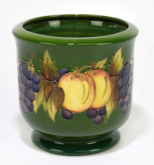 MOORCROFT; a jardinière decorated with fruits on a green ground,...