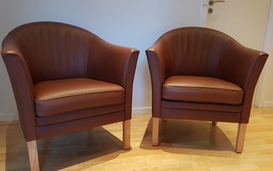 Mogens Hansen & Lars Kalmar: “Dronningestolen”. A pair of easy chairs with wooden legs. Seat, back and sides upholstered with cognac coloured leather. (2)