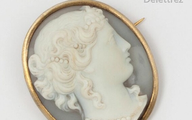 Oval metal brooch, adorned with a cameo on agate representing a woman in profile adorned with pearls. Dimensions: 3.2 x 3.7cm.