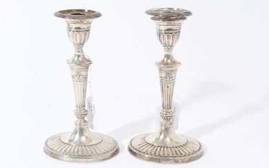 Pair of Victorian silver candlesticks with fluted tapering stems, urn-shaped candle holder with separate sconces, on fluted and reeded oval bases, (London 1895), 19cm in overall height