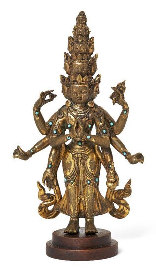 Property of a Gentleman (lots 36-85) A Sino-Tibetan gilt-bronze turquoise inlaid standing figure of Avalokiteshvara, 19th century, depicted with eleven heads arranged in five tiers, the top with a small head of Amitabha Buddha, above a slender body...