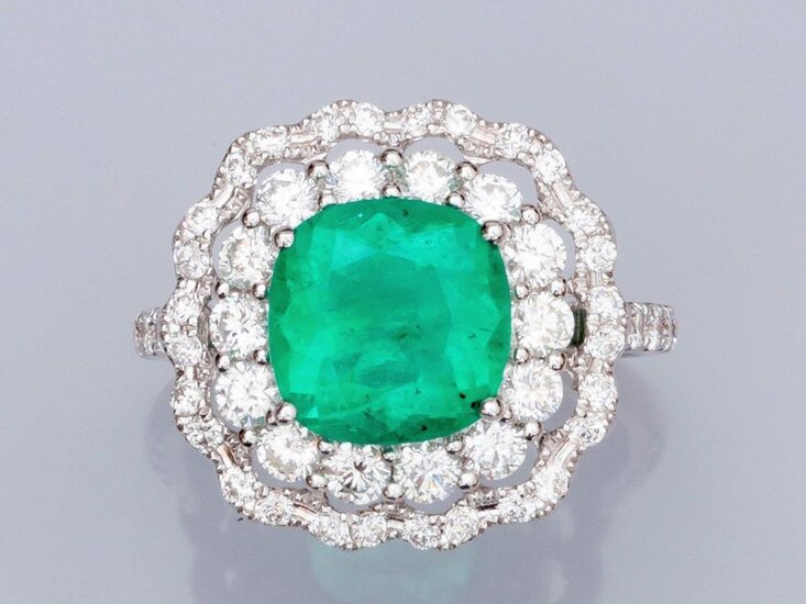Ring in white gold 750°/00 (18K), set with a cushion emerald of about 3.50 carats (Colombia, traces of resin), double surrounded by brilliant-cut diamonds. 6.20 g. TDD 55. Width: 17.9 mm. Eagle's head punch