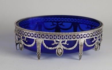 Silver jardiniere, 833/00, with blue glass inner container. Oval openwork dish decorated with garlands and medallions. Equipped with sawn and pearl edge. 2x broken at garland. jl .: presumably D: 1913. 25x18x8cm ;. In reasonably good condition