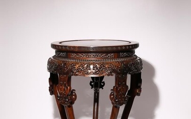 UNE TABLE EN BOIS DUR CHINOISE QIANLONG 1736-95 Le dessus circulaire sculpté avec une frette...
