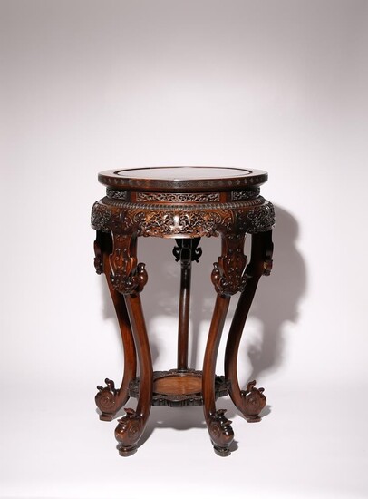 UNE TABLE EN BOIS DUR CHINOISE QIANLONG 1736-95 Le dessus circulaire sculpté avec une frette...