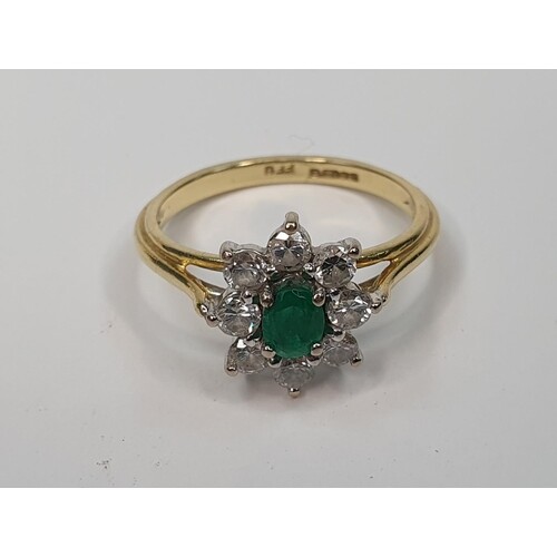 18ct yellow gold ring set with an oval cut Emerald surrounde...
