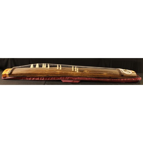 A Chinese guzheng, of typical form, 183cm long, carrying cas...