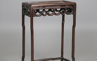 A Chinese hardwood occasional table, early 20th century, the rectangular panelled top with carved an