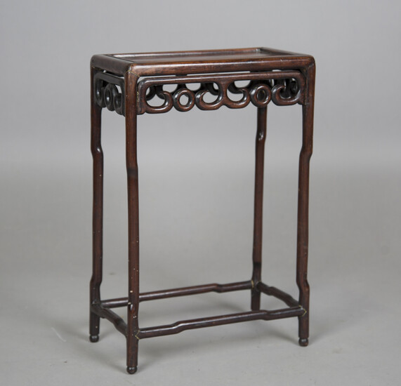 A Chinese hardwood occasional table, early 20th century, the rectangular panelled top with carved an