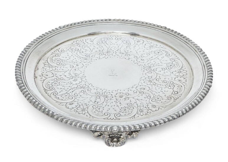 A George IV silver salver, London, 1822, Philip Rundell, of circular form with gadrooned edge, the later decorated base engraved with stag crest and raised on three bracket feet, 25.8cm dia., approx. weight 20.3oz