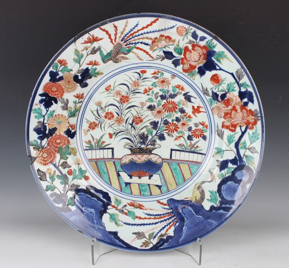 A Japanese Imari porcelain circular dish, late 17th century, painted with a flower charged urn withi