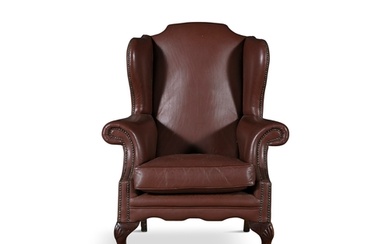 A MAHOGANY FRAMED WINGBACK ARMCHAIR, upholstered in a brow...