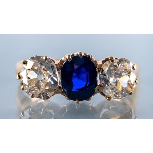 A SAPPHIRE AND DIAMOND THREE STONE RING, the central oval fa...