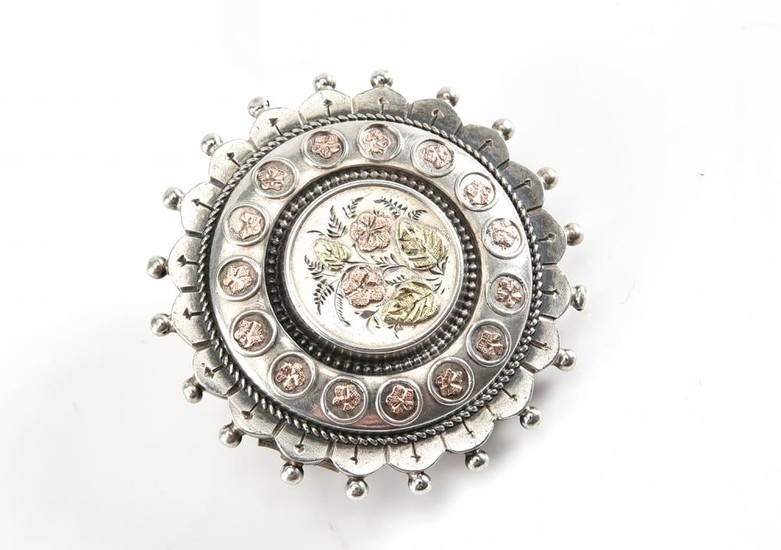 A VICTORIAN TARGET BROOCH IN STERLING SILVER WITH GOLD INLAY