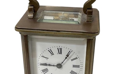 A brass cased carriage clock, the white enamel dial set...