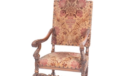 A carved walnut and Damask velvet upholstered elbow chair in...