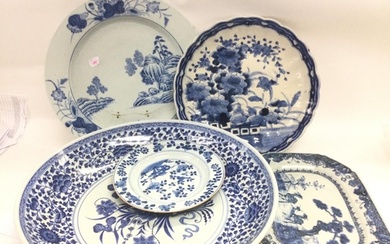 A collection of blue and white chargers, plates and dishes. ...